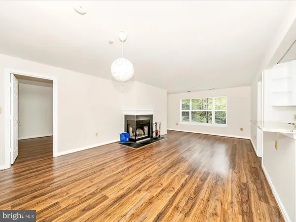 an empty room with wooden floor and fireplace