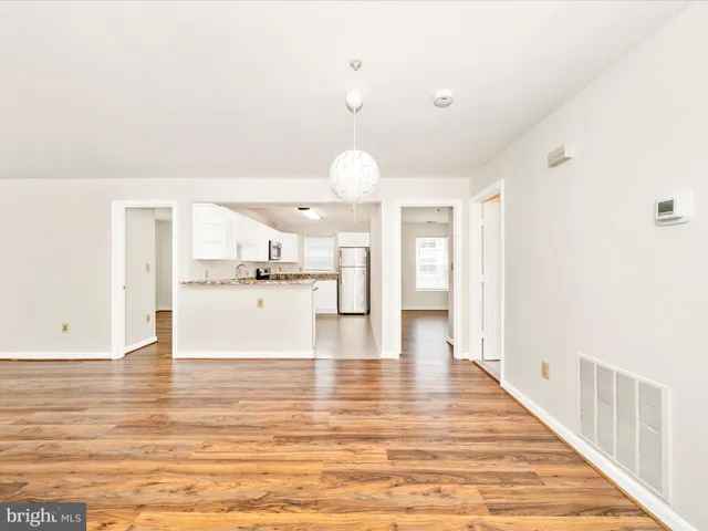 a view of kitchen and hall with wooden floor