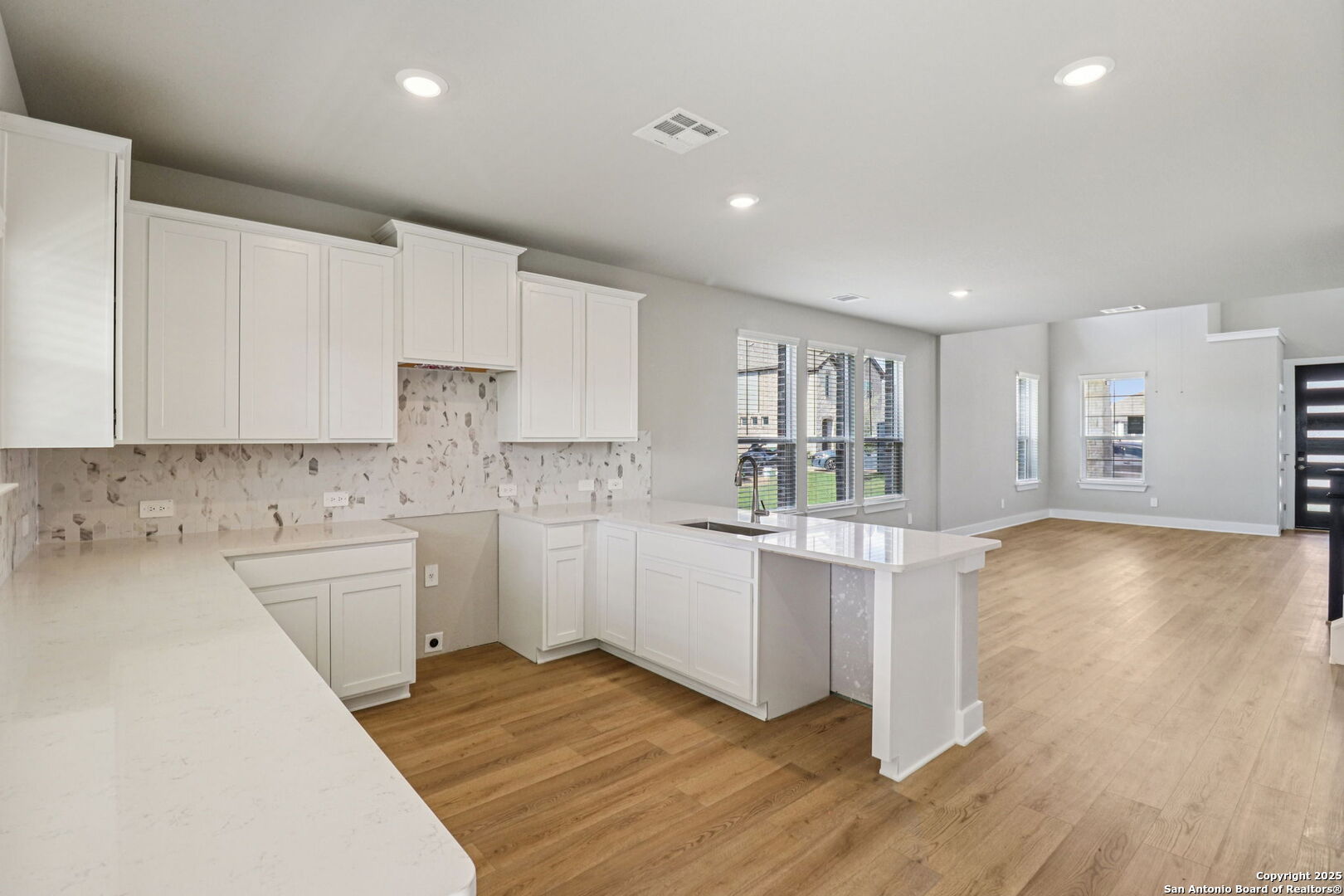 12602 Winding Butte Schertz, TX 78154 - Photo 9 of 46 a kitchen with white cabinets and wooden floor