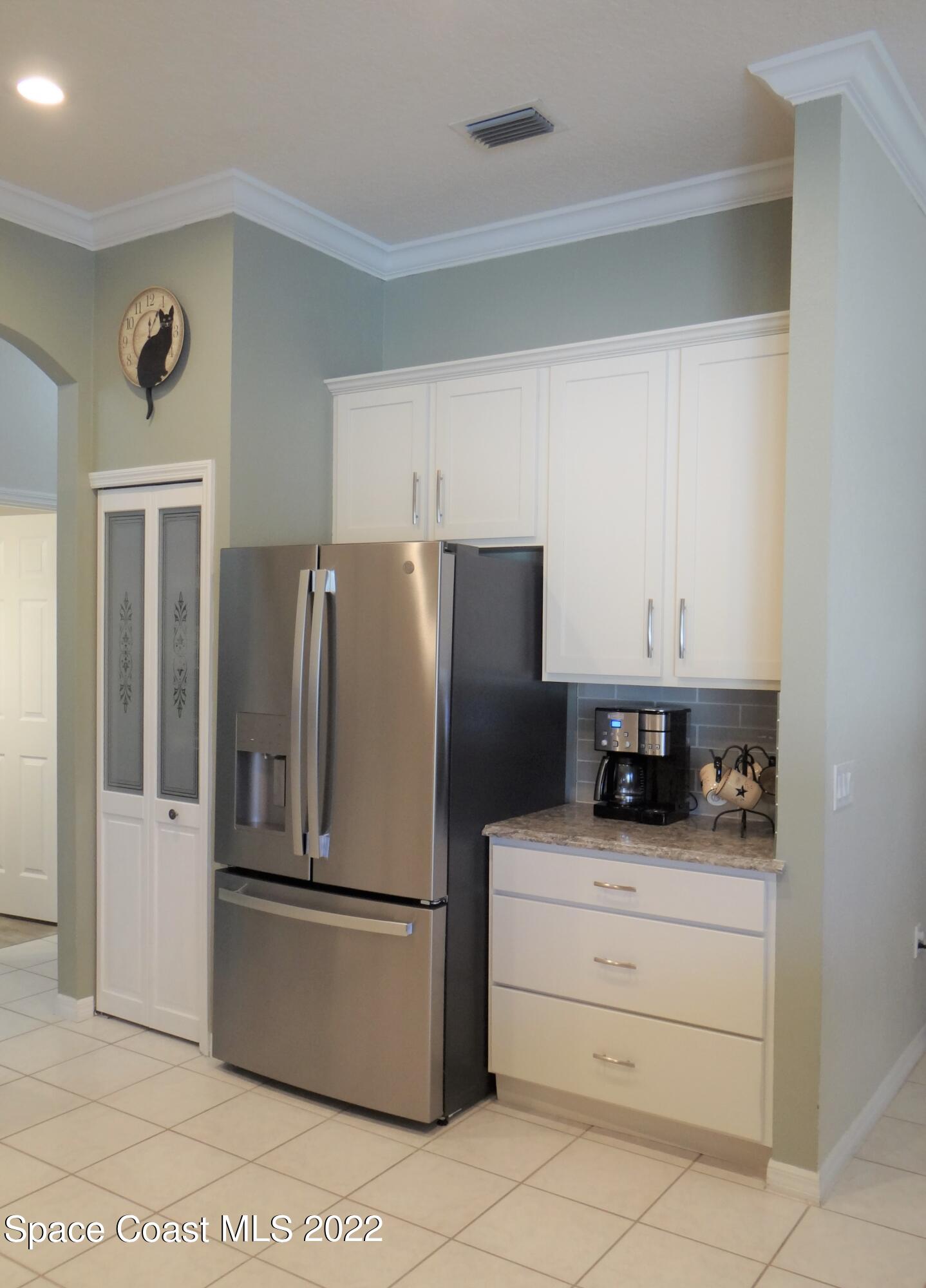 3100 Huntleigh Way Melbourne, FL 32934 - Photo 15 of 54 a kitchen with appliances a refrigerator and cabinets