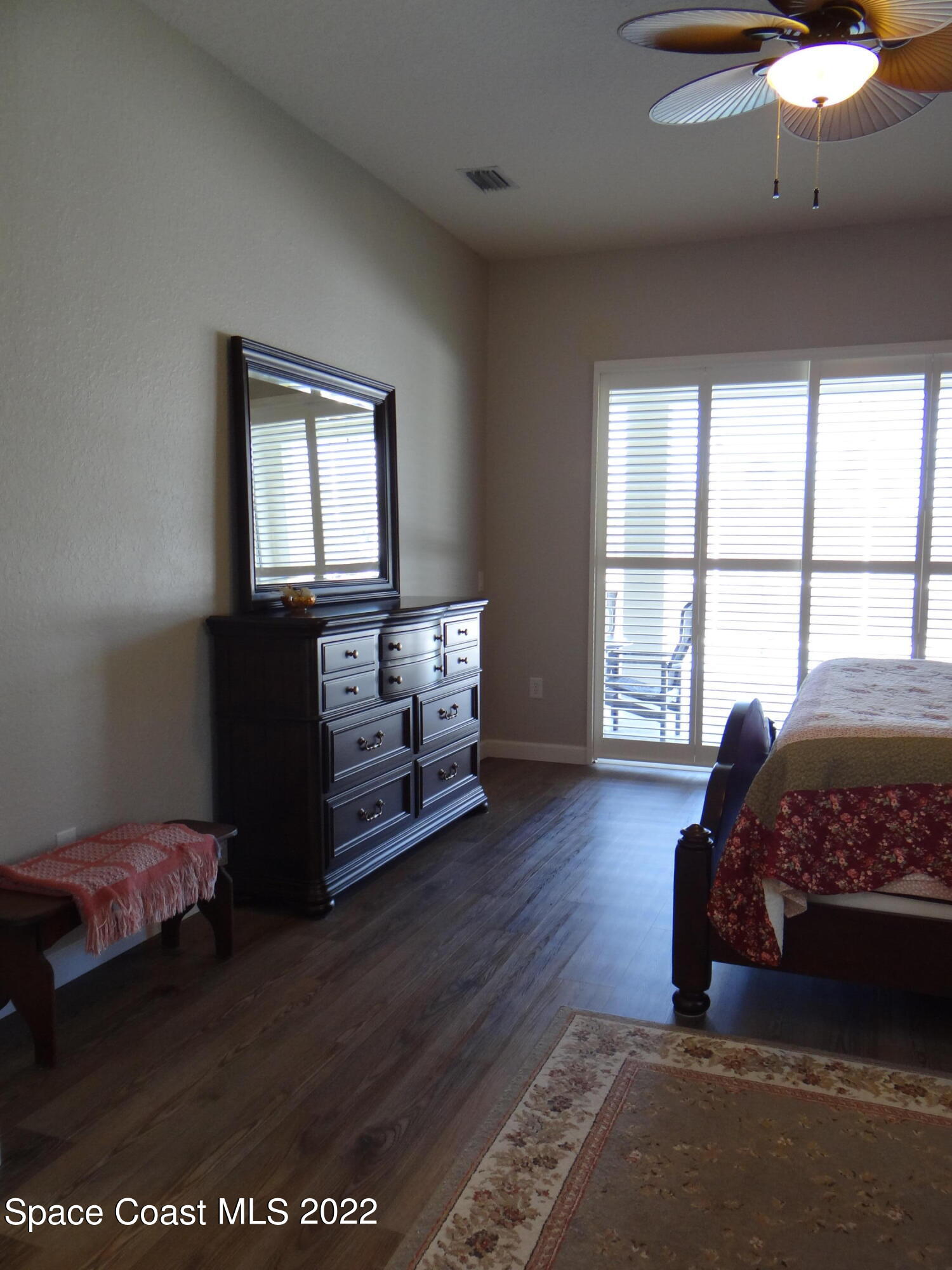 3100 Huntleigh Way Melbourne, FL 32934 - Photo 23 of 54 a bedroom with a bed and wooden floor