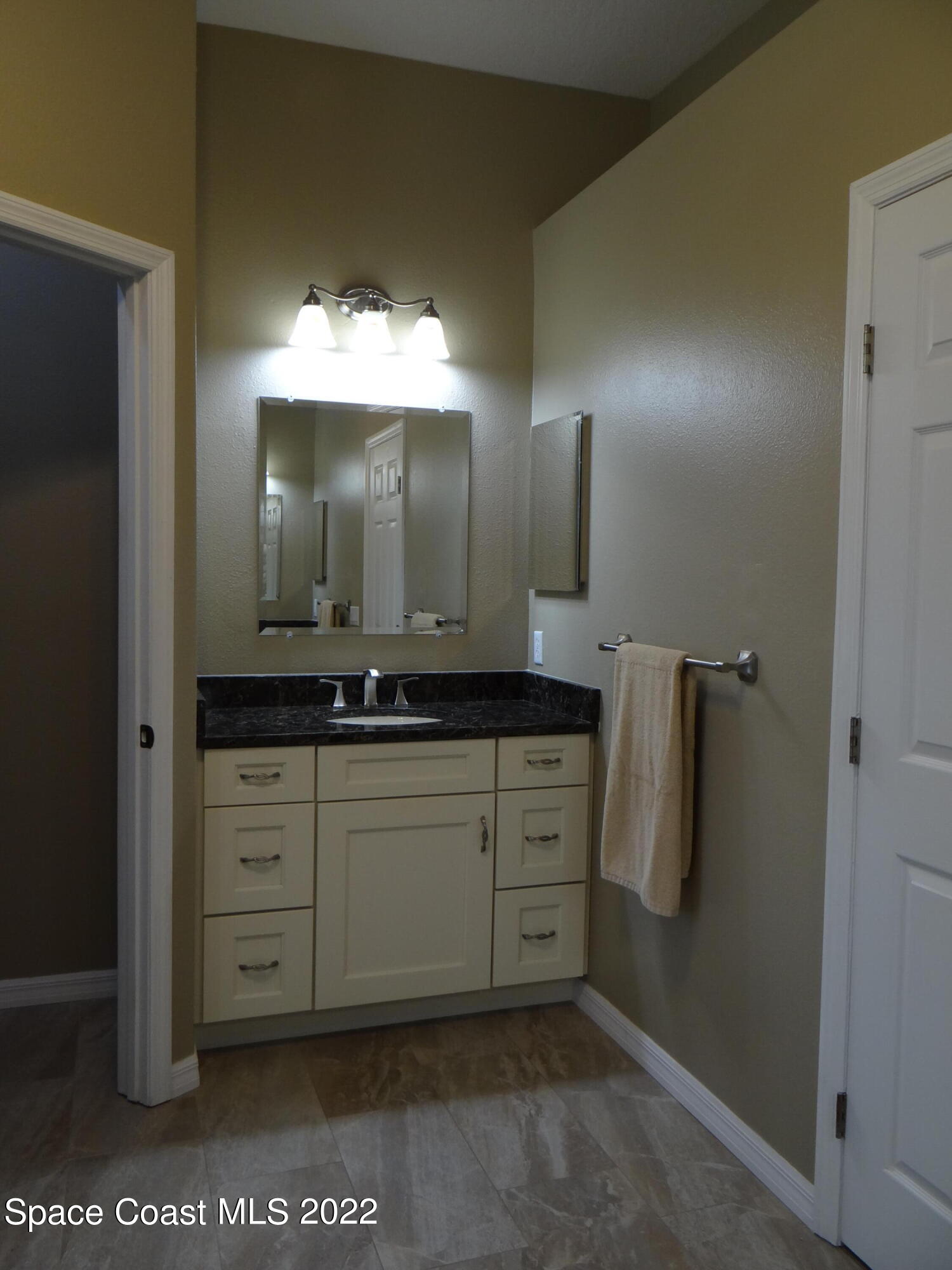 3100 Huntleigh Way Melbourne, FL 32934 - Photo 27 of 54 a bathroom with a sink and a mirror