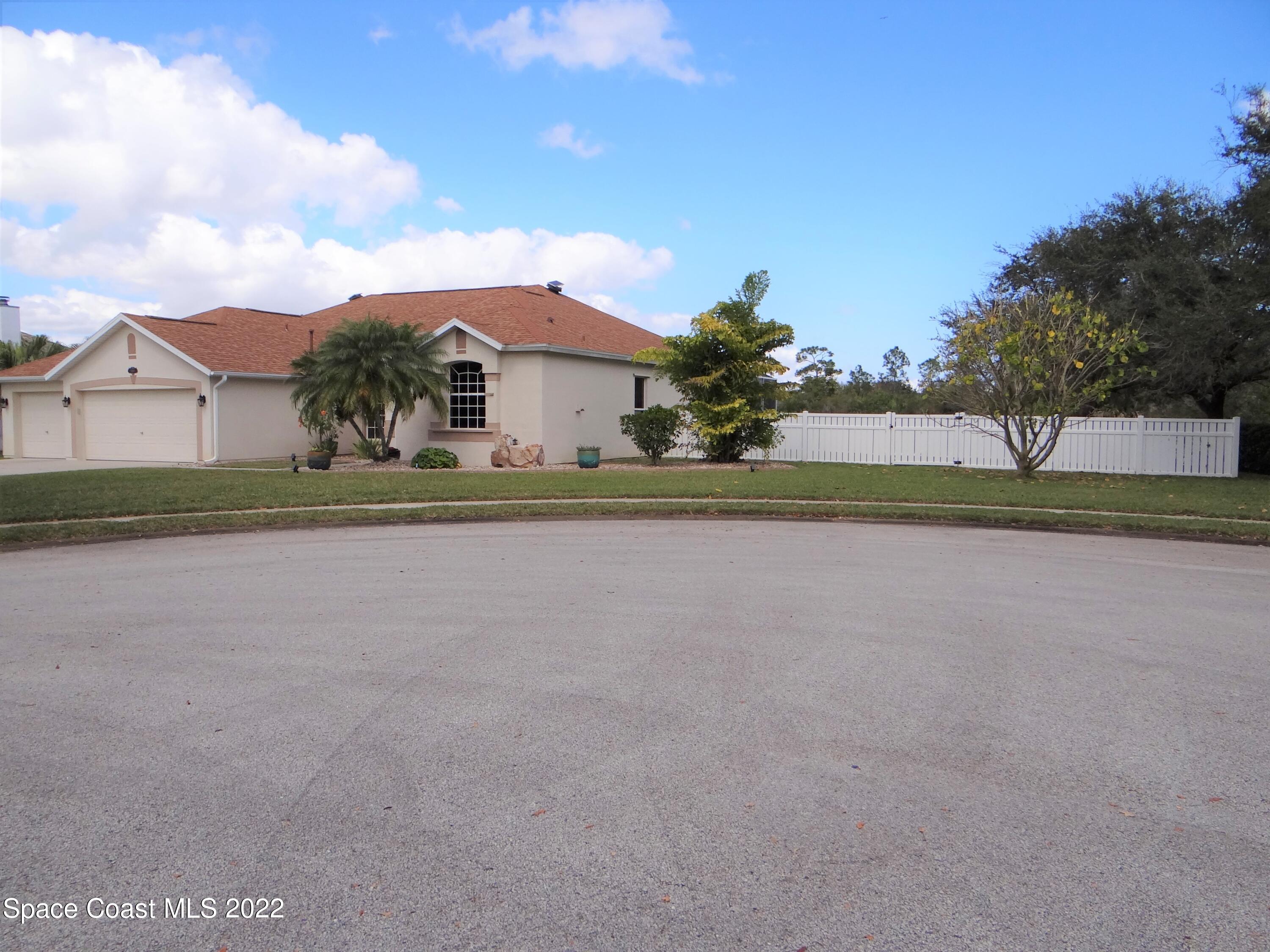 3100 Huntleigh Way Melbourne, FL 32934 - Photo 3 of 54 a front view of a house with a yard and garage