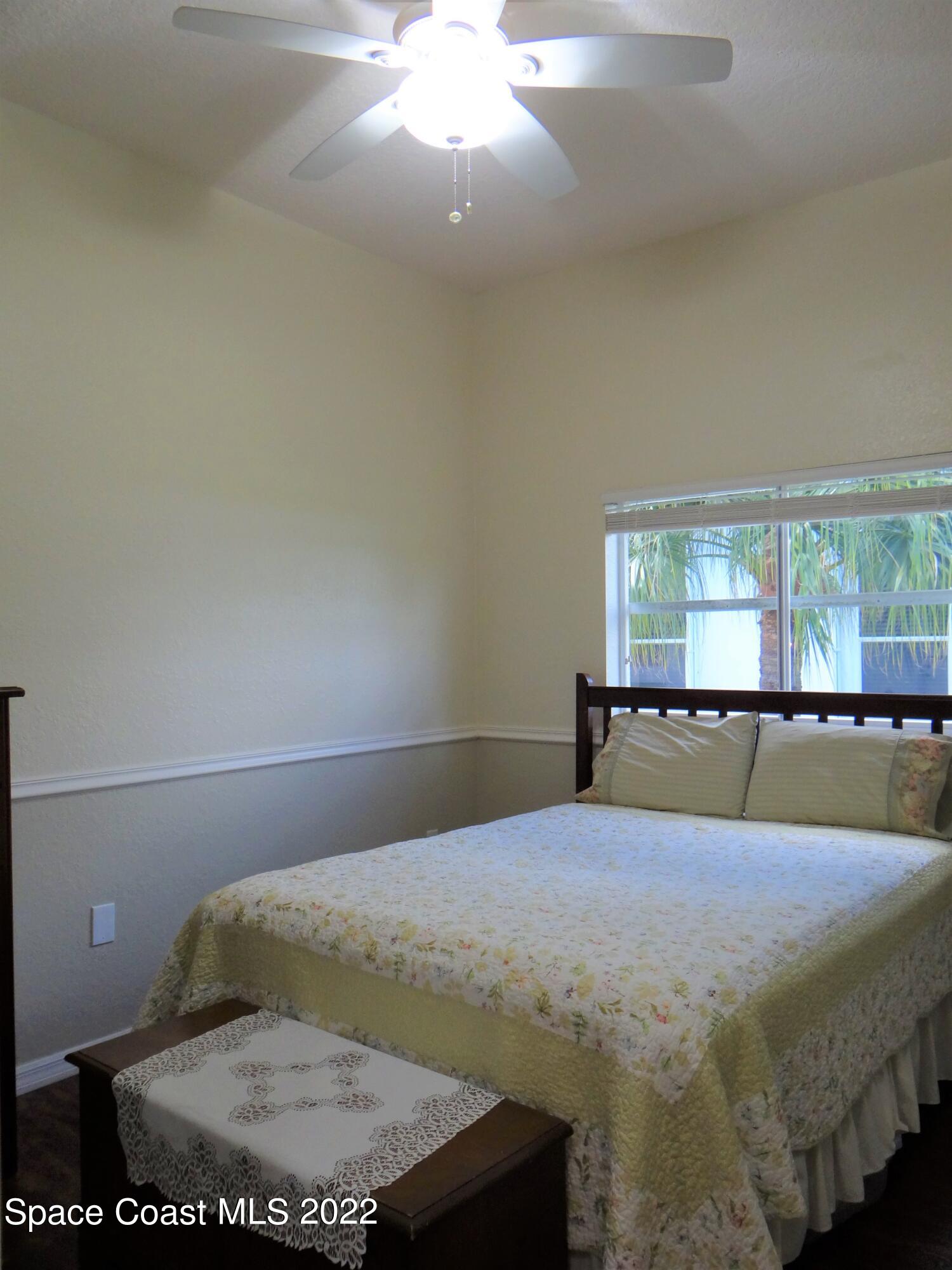 3100 Huntleigh Way Melbourne, FL 32934 - Photo 31 of 54 a bedroom with a bed and chandelier