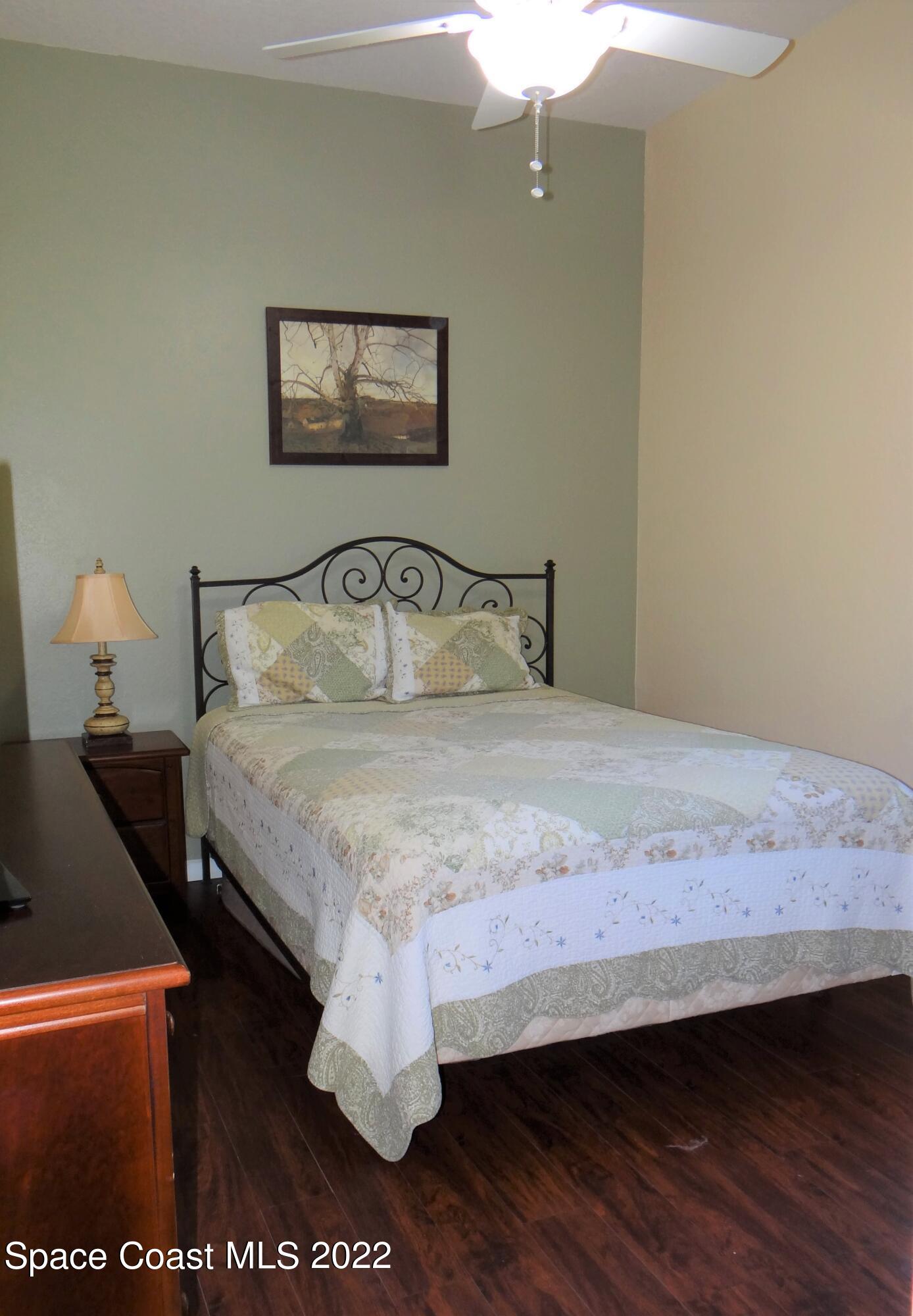 3100 Huntleigh Way Melbourne, FL 32934 - Photo 37 of 54 a bedroom with a bed and a painting on the wall