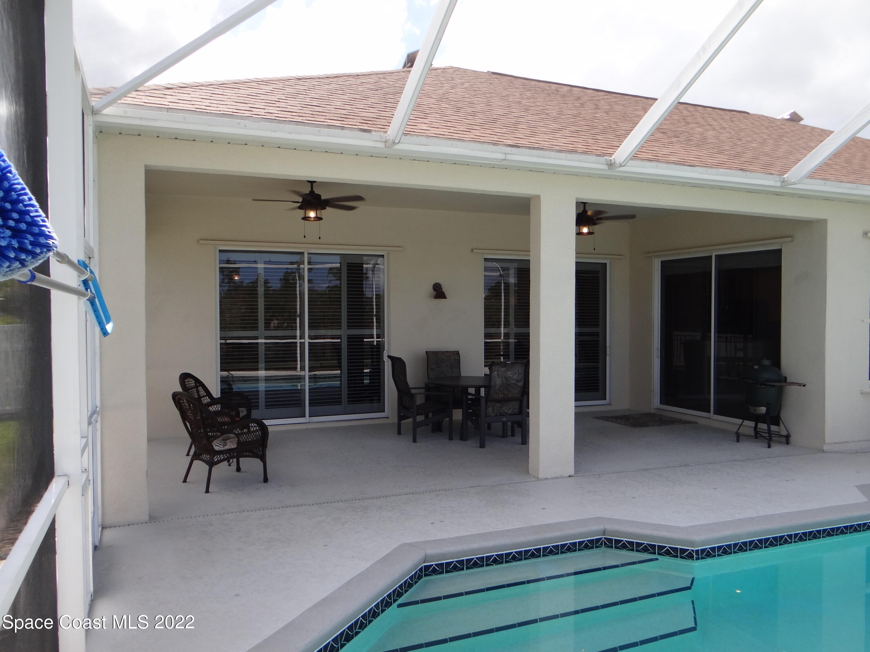 3100 Huntleigh Way Melbourne, FL 32934 - Photo 42 of 54 a front view of a house with outdoor seating and wooden floor
