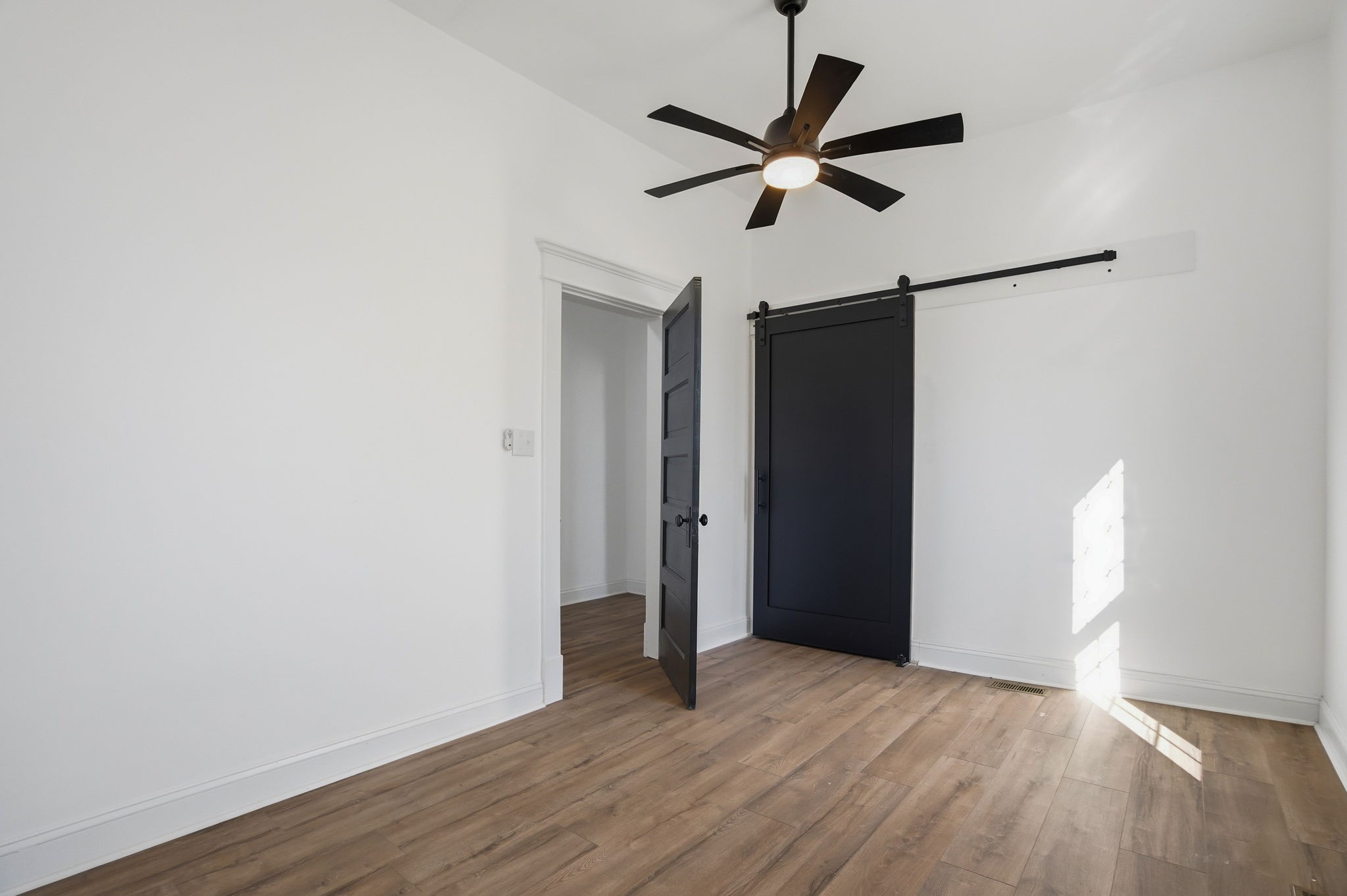 204 Winters Street Adams, TN 37010 - Photo 11 of 18 a view of a big room with wooden floor and a ceiling fan