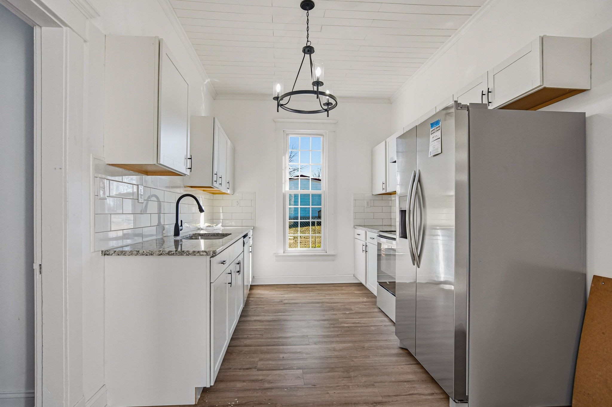 204 Winters Street Adams, TN 37010 - Photo 13 of 18 a kitchen with stainless steel appliances granite countertop a refrigerator a sink dishwasher a stove and white cabinets with wooden floor