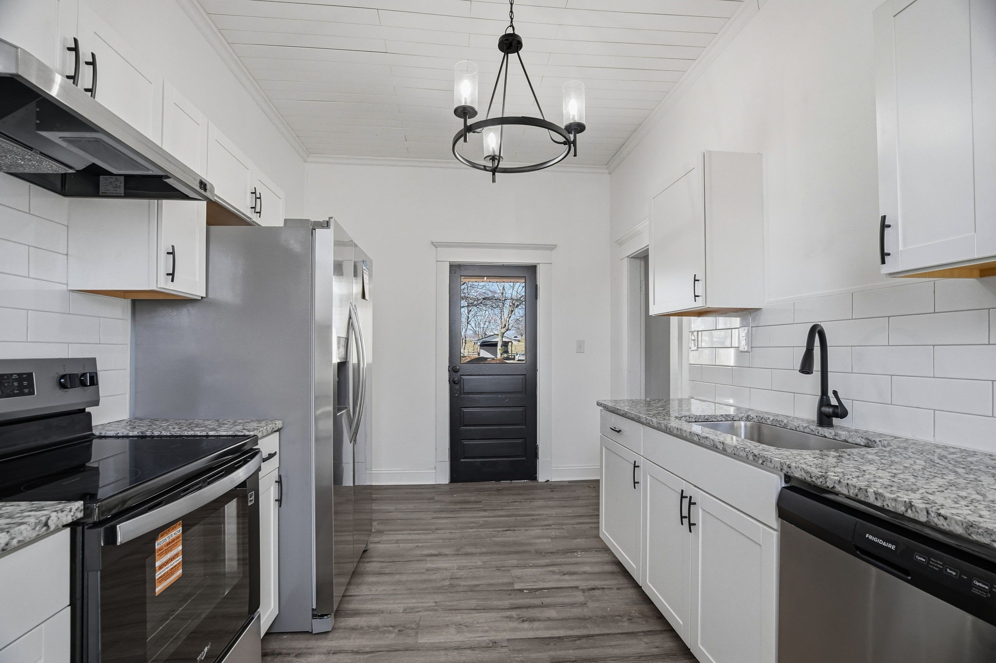 204 Winters Street Adams, TN 37010 - Photo 16 of 18 a kitchen with stainless steel appliances granite countertop a sink a stove and a wooden floors