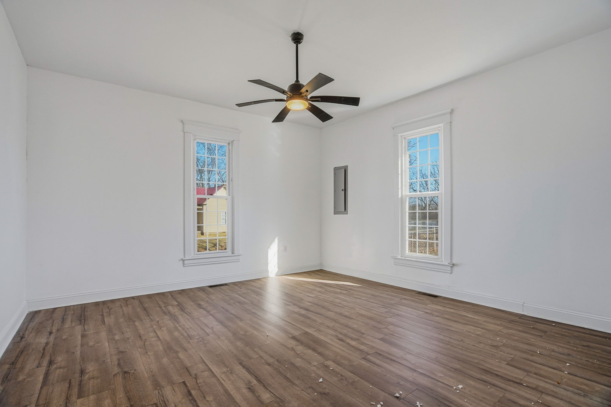 204 Winters Street Adams, TN 37010 - Photo 7 of 18 an empty room with wooden floor ceiling fan and windows