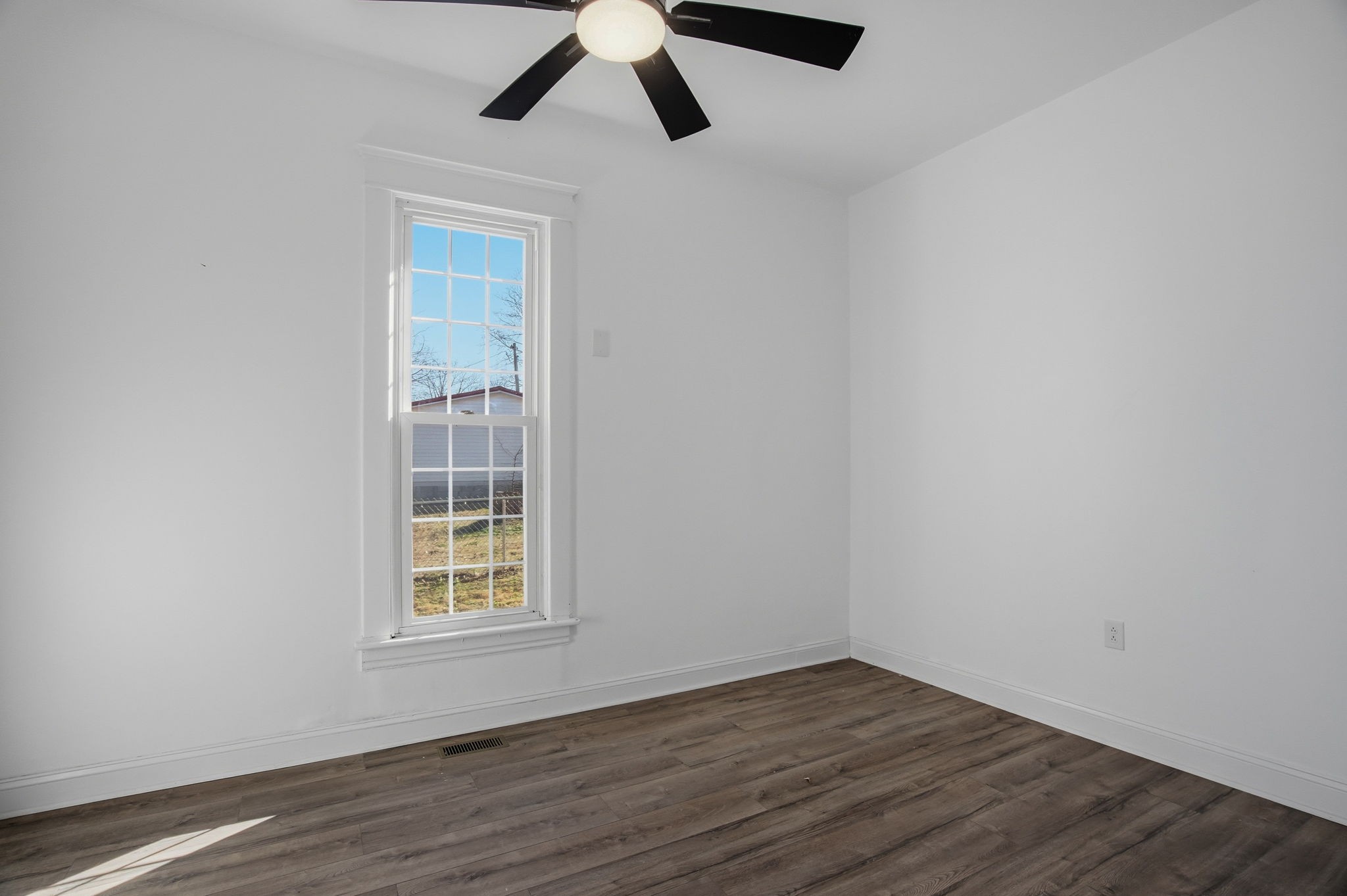 204 Winters Street Adams, TN 37010 - Photo 10 of 18 an empty room with wooden floor and windows