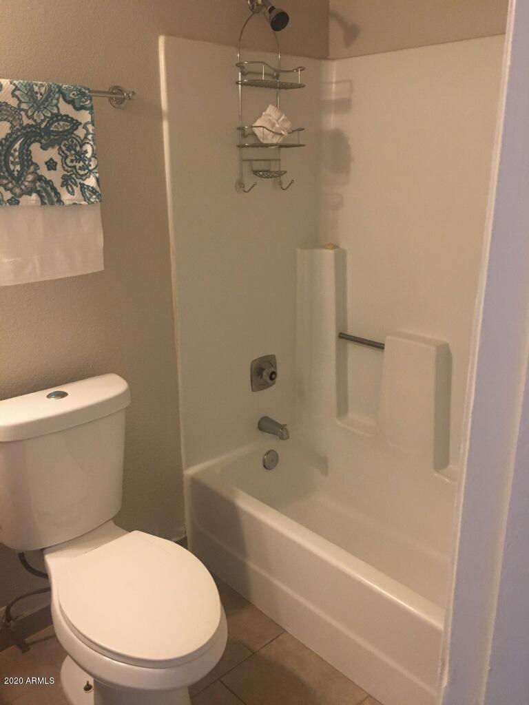 7401 West Hatcher Road Peoria, AZ 85345 - Photo 4 of 5 a white toilet sitting next to a bath tub and a shower