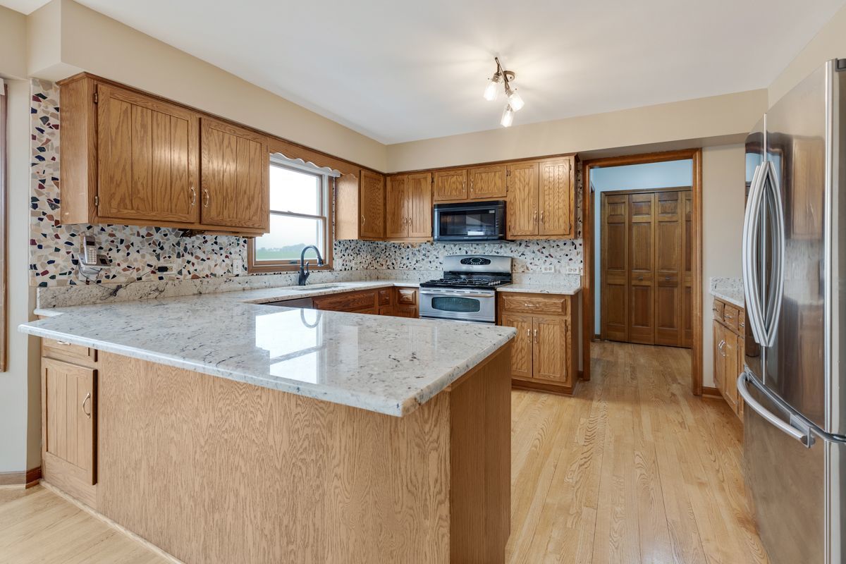 753 Millview Drive Batavia, IL 60510 - Photo 7 of 30 a kitchen with stainless steel appliances granite countertop a sink stove and refrigerator