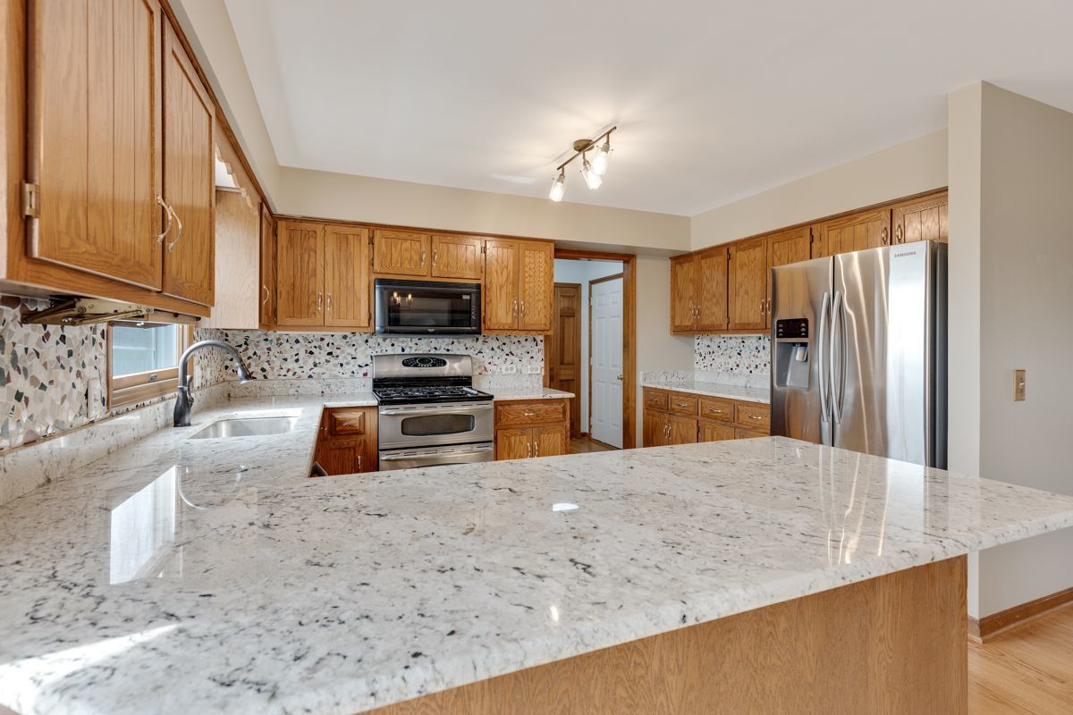 753 Millview Drive Batavia, IL 60510 - Photo 10 of 30 a kitchen with stainless steel appliances granite countertop a sink refrigerator and microwave