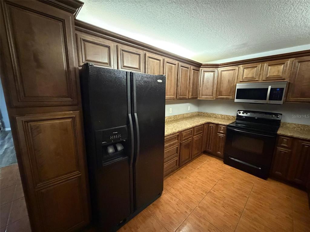9816 East Granada Court Inverness, FL 34450 - Photo 16 of 28 a kitchen with stainless steel appliances granite countertop a refrigerator and a sink