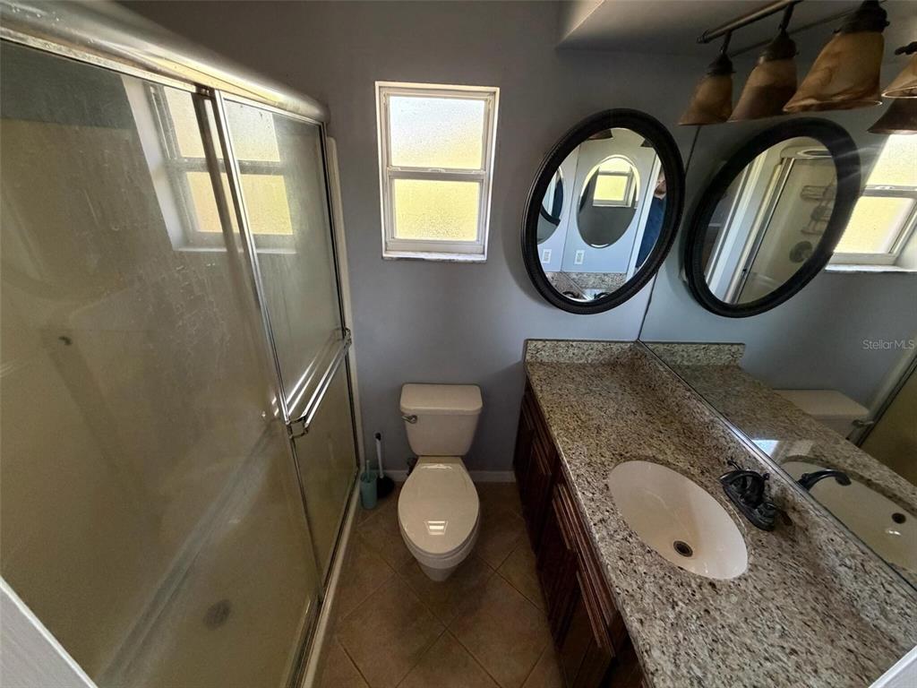9816 East Granada Court Inverness, FL 34450 - Photo 22 of 28 a bathroom with a granite countertop toilet sink and mirror