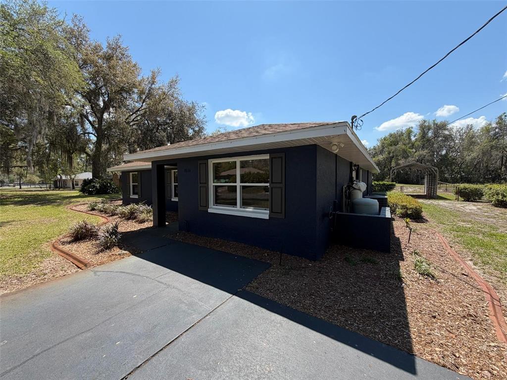 9816 East Granada Court Inverness, FL 34450 - Photo 3 of 28 a view of a backyard with table and chairs under an umbrella