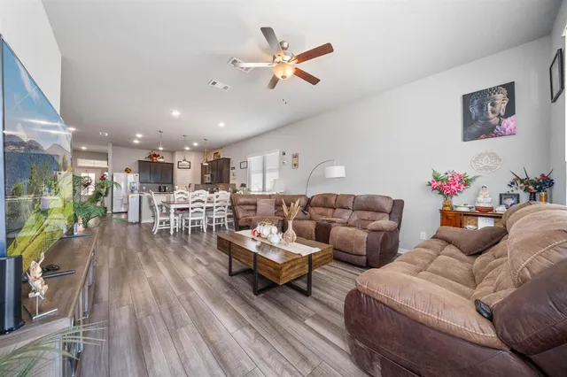 a living room with furniture kitchen view and a potted plant