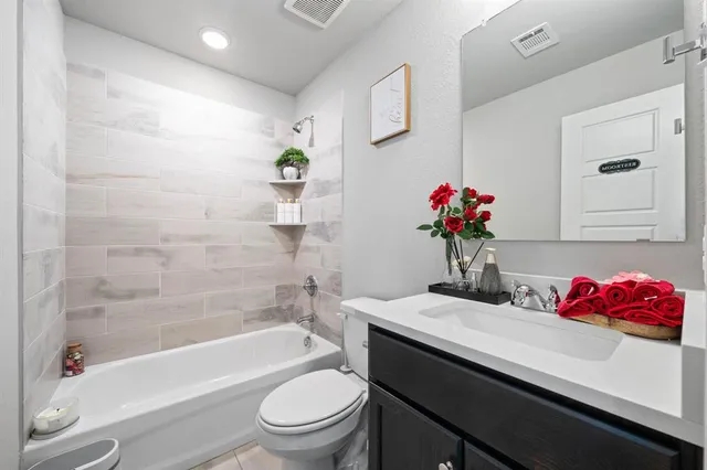 a bathroom with a granite countertop sink a toilet and shower