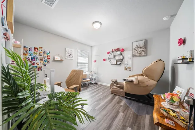 a living room with furniture rug toys and wooden floor