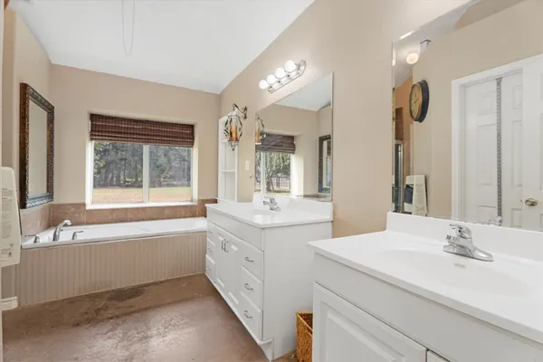 a bathroom with a tub sink and mirror