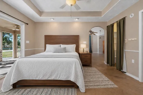 a bedroom with a large bed and a chandelier