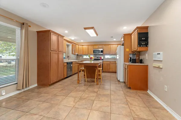 a kitchen with stainless steel appliances granite countertop a refrigerator and a stove top oven