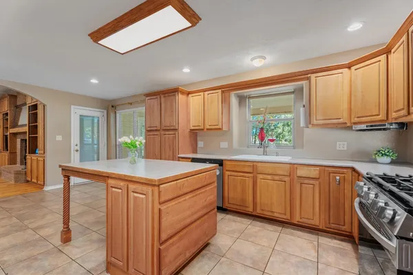 a kitchen with stainless steel appliances granite countertop a stove a sink and a refrigerator
