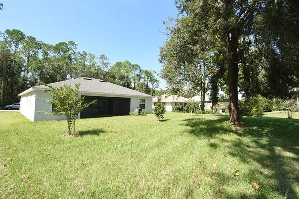 a house is sitting in middle od the grass