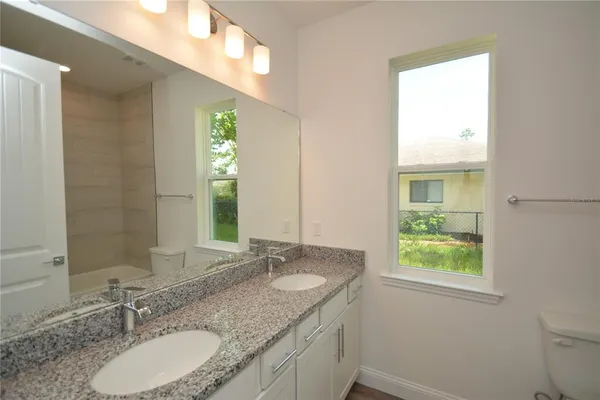 a bathroom with a granite countertop sink and a mirror