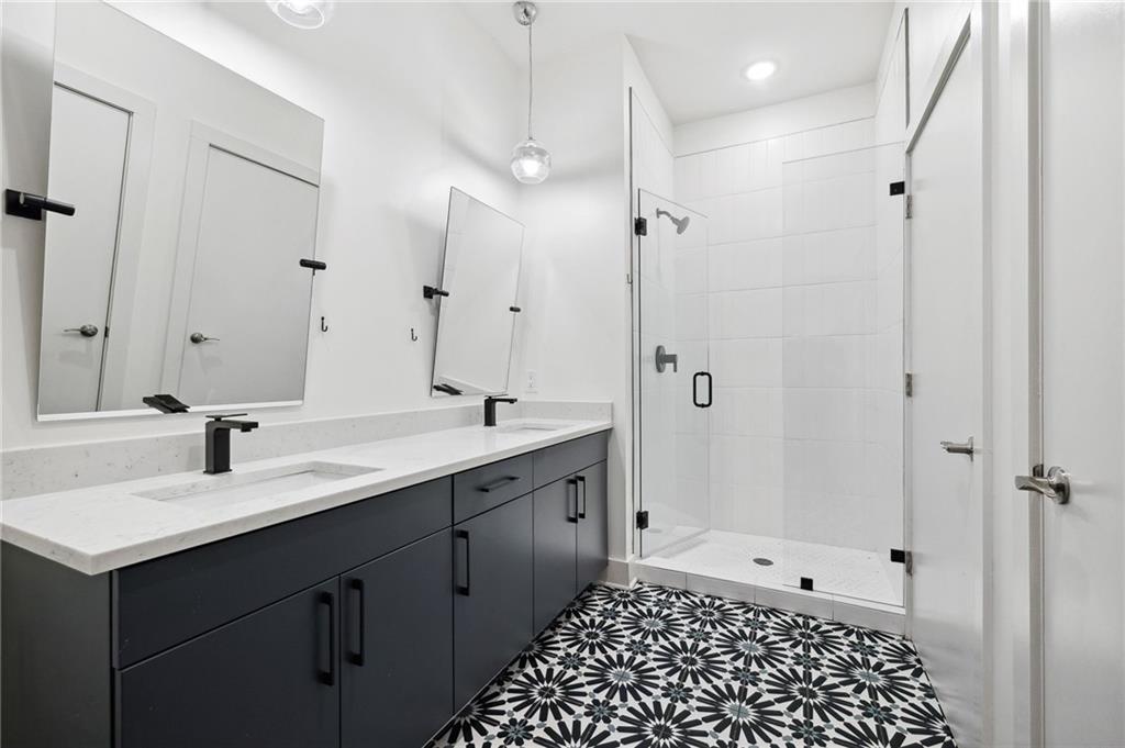 112 Rogers Street Northeast, Unit 304 Atlanta, GA 30317 - Photo 11 of 22 a bathroom with a sink a toilet a shower and a mirror