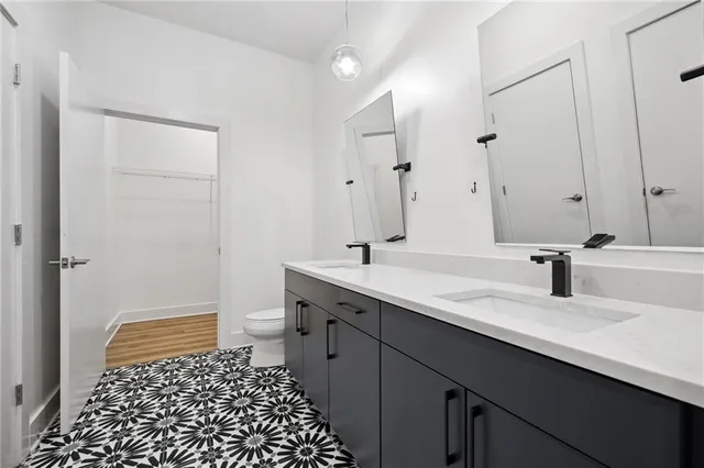a bathroom with a granite countertop sink a toilet and a mirror