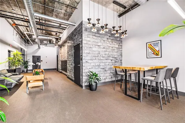 a view of a dining room with furniture one side kitchen view and wooden floor