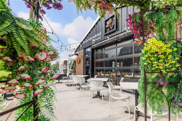 a view of a patio with dining table and chairs and flower plants