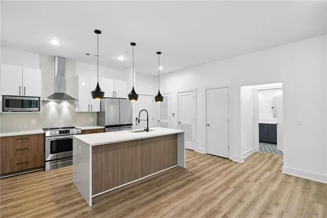 a kitchen with stainless steel appliances granite countertop a sink stove and refrigerator