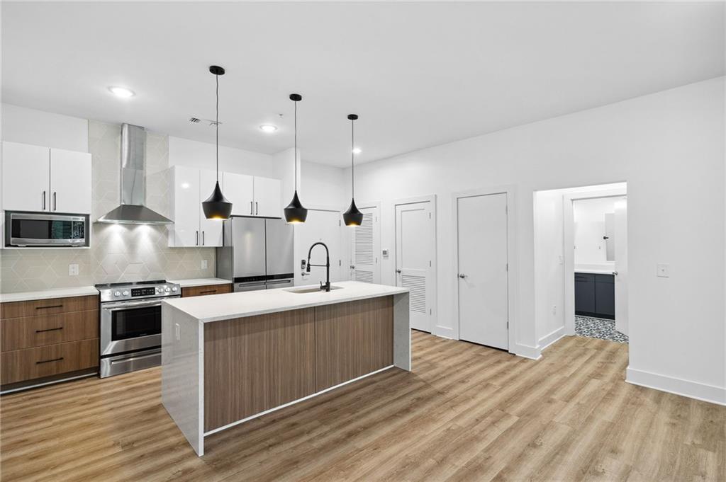 112 Rogers Street Northeast, Unit 304 Atlanta, GA 30317 - Photo 2 of 22 a kitchen with stainless steel appliances granite countertop a sink stove and refrigerator