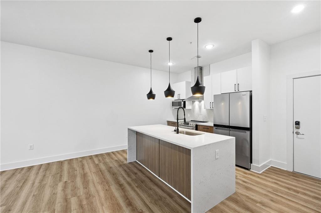 112 Rogers Street Northeast, Unit 304 Atlanta, GA 30317 - Photo 6 of 22 a kitchen with a sink a refrigerator and window