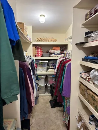 a view of walk in closet with clothes and shoes