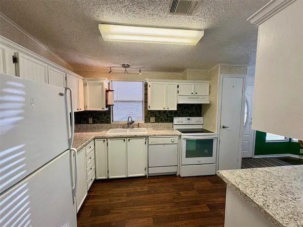 a kitchen with stainless steel appliances granite countertop a stove a sink and a refrigerator
