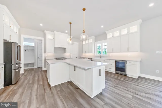 a large kitchen with granite countertop a large counter top a sink stainless steel appliances and cabinets