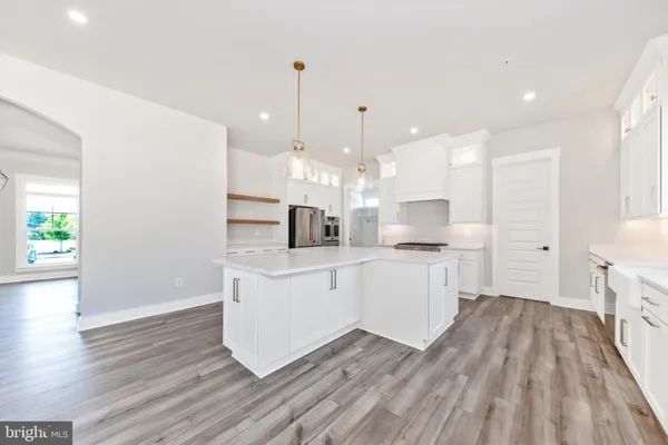 a large white kitchen with a white wooden floor