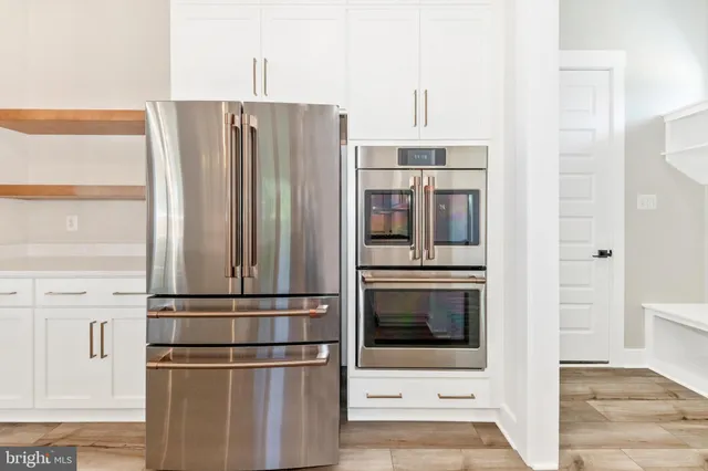 a kitchen with stainless steel appliances granite countertop a refrigerator and a stove top oven