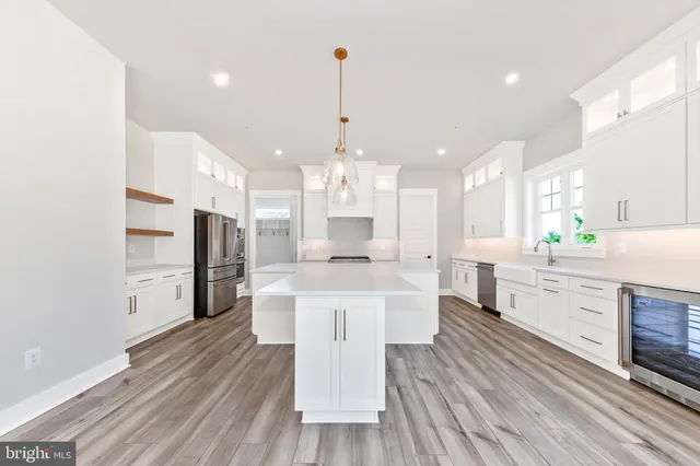 a large kitchen with cabinets wooden floor and stainless steel appliances