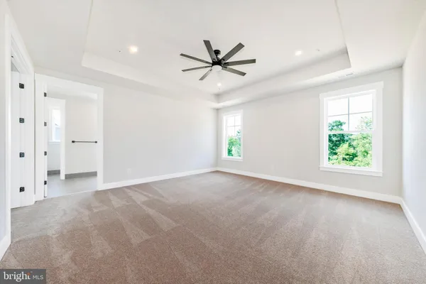 an empty room with windows and a ceiling fan