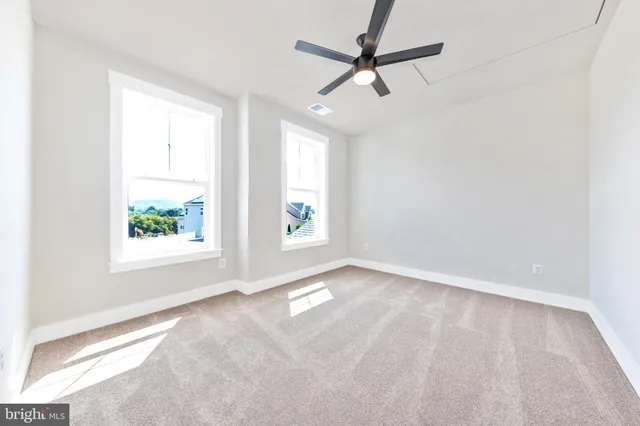 an empty room with a window and a fan