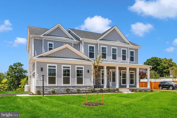 a front view of a house with yard and green space