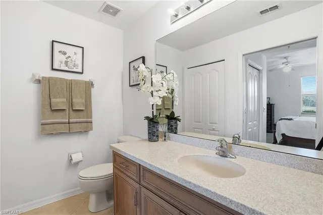 a bathroom with a granite countertop sink toilet and mirror