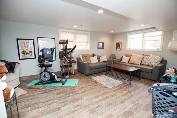 a living room with furniture a window and gym equipment