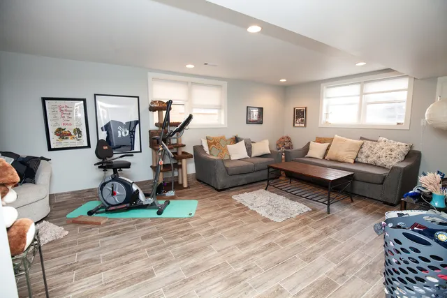 a living room with furniture a window and gym equipment