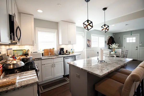 a kitchen with stainless steel appliances granite countertop a sink a stove and a refrigerator